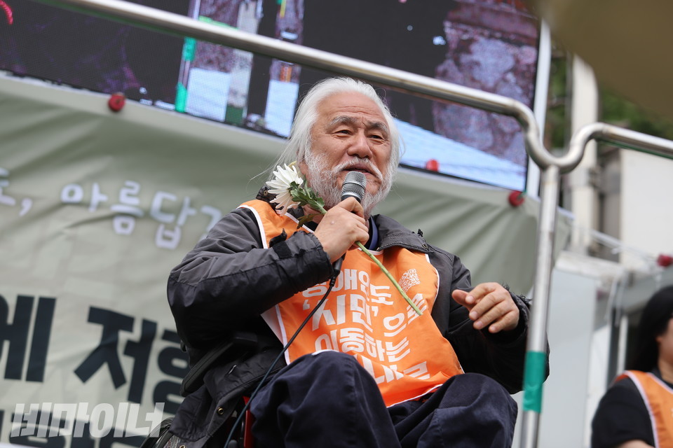 박경석 전국장애인차별철폐연대 상임공동대표가 한 손에 국화꽃을 든 채 발언하고 있다. 사진 김소영