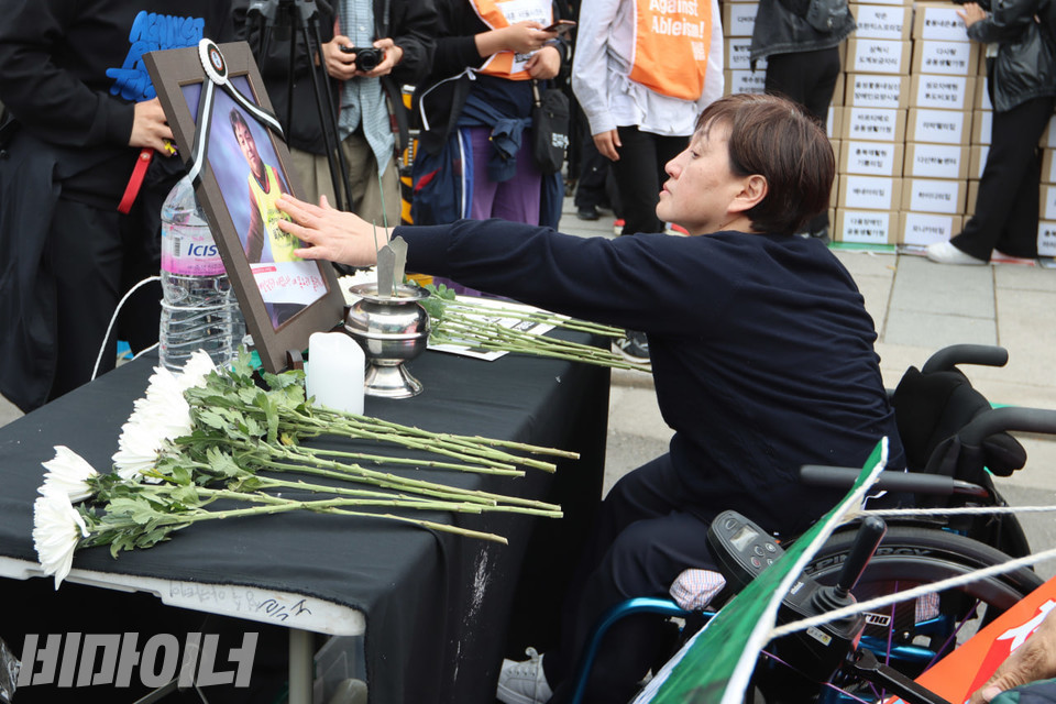 김용섭 운동가의 영정사진을 어루만지는 박영림 늘해랑보호작업장 원장. 사진 김소영