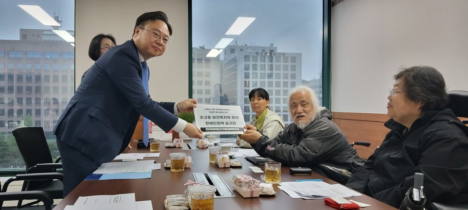 박경석 전장연 상임공동대표(오른쪽)가 조규홍 복지부 장관(왼쪽)에게 장애인정책 요구안을 전달하고 있다. 사진 전장연