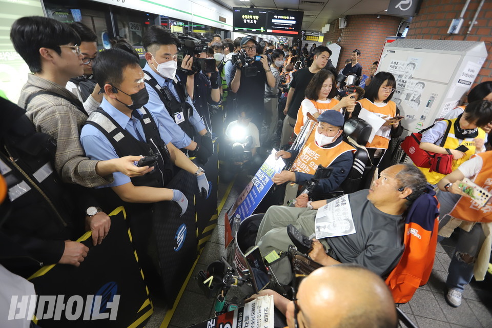 전국장애인차별철폐연대가 13일 오후 3시 서울 지하철 2호선 시청역 승강장에 모여 오세훈 서울시장에게 대화를 촉구했다. 서울교통공사 보안관들이 방패로 변형한 휠체어 안전 발판을 든 채 장애인들의 앞을 가로막고 있다. 사진 김소영