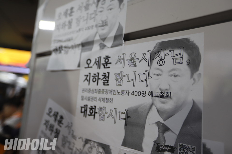 시청역 벽에 붙은 스티커. 스티커에는 오세훈 시장의 사진과 함께 “오세훈 서울시장님, 지하철 탑니다. 대화합시다”, “권리중심최중증장애인노동자 400명 해고 철회”, “탈시설권리 삭제 철회”라고 적혀있다. 사진 김소영