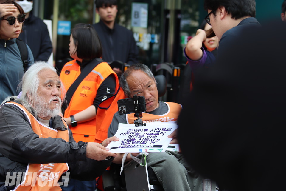 박경석 전장연 대표와 이규식 서울장차연 대표가 김동은 서울시 장애인복지정책팀장에게 오세훈 서울시장과의 면담요청서 공문을 전달하고 있다. 사진 김소영