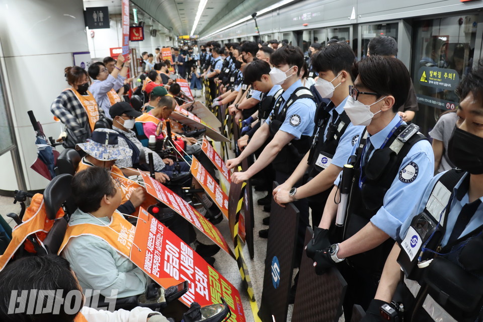 4일 오전 8시. 광화문역 승강장에 휠체어를 탄 사람 20여 명, 휠체어 비이용자 40여 명이 모여 대통령 취임식 맞이 기자회견을 하고 있다. 서울교통공사 보안관들이 방패로 변형한 발판을 들고 장애인들 앞을 가로막고 있다. 사진 김소영
