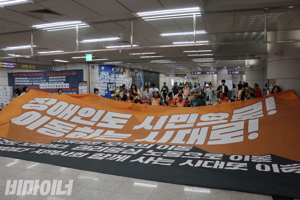 장애인들이 국회의사당역사 내에서 대통령 취임식 맞이 투쟁을 마무리하고 있다. “장애인도 시민으로! 이동하는 시대로!”라고 적힌 큰 천막이 펼쳐져 있다. 사진 김소영