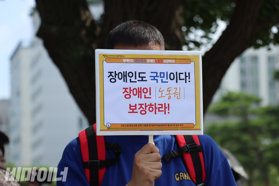 지난해 7월 30일, 인천시청 앞에서 열린 장애인의 노동권 보장을 요구하는 기자회견에서 참석자가 “장애인도 국민이다! 장애인 노동권 보장하라!”라고 적힌 팻말을 들고 있다. 사진 김소영