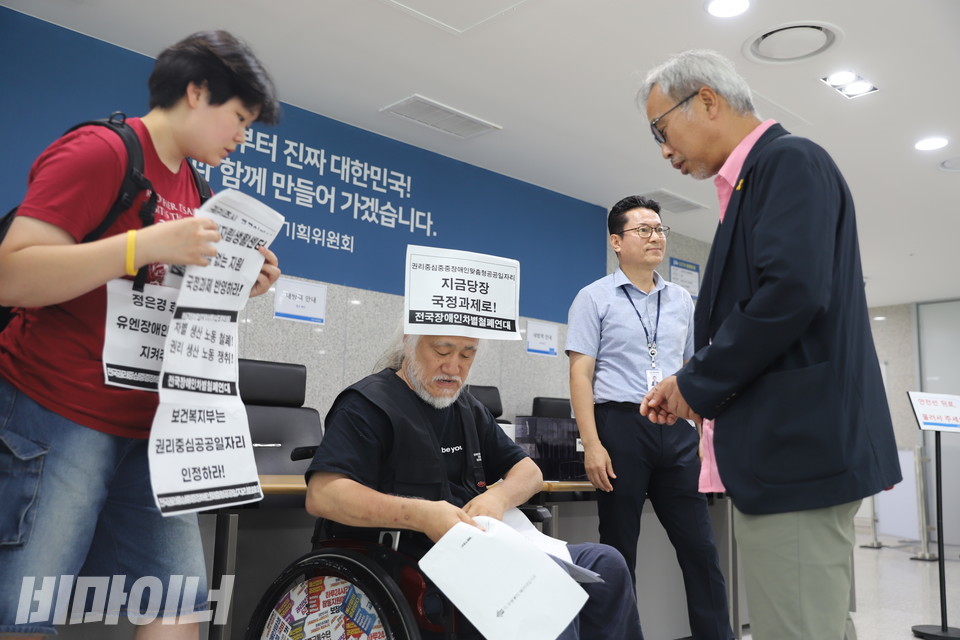 박경석 전장연 상임공동대표가 이태호 위원에게 요구안을 전달하고 있다. 사진 김소영