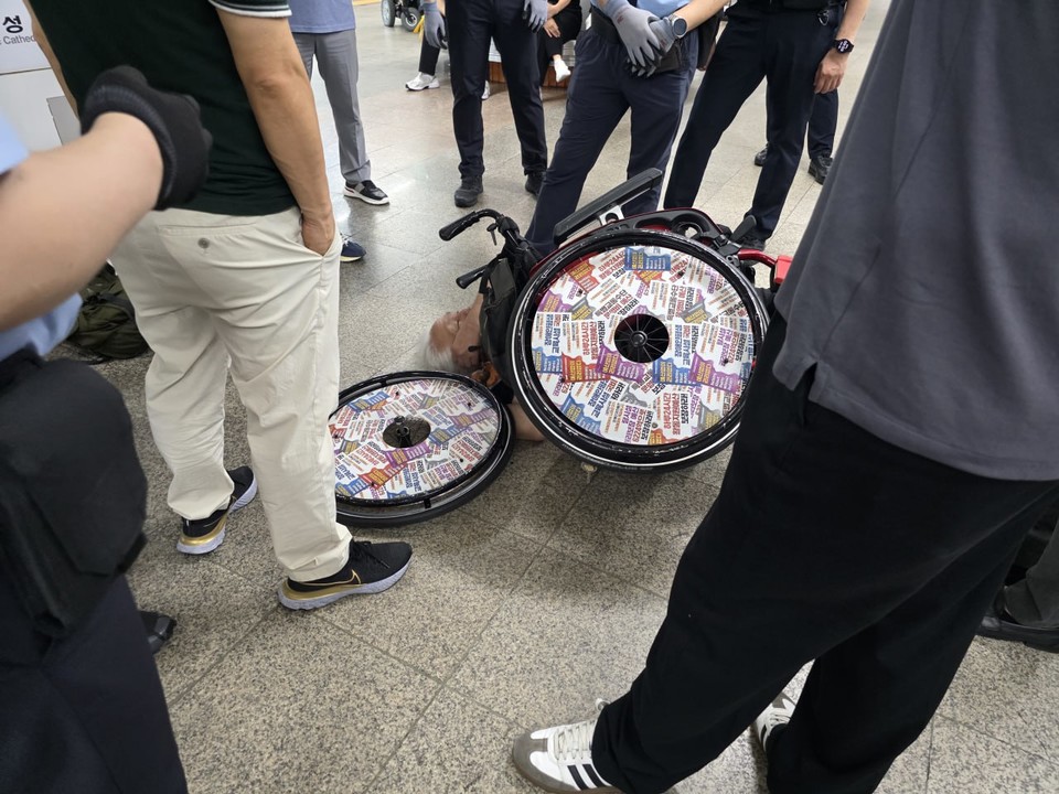 휠체어에서 떨어진 박경석 전장연 대표. 휠체어 또한 파손됐다. 사진 전장연