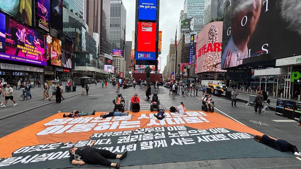 북미 AA CRPD 대표단이 뉴욕 타임스퀘어 앞 다이인(die-in) 행동을 진행하고 있다. 사진 전장연