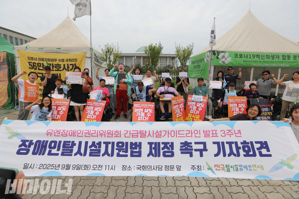 9일 오전 11시, 국회 앞에서 열린 장애인탈시설지원법 제정 촉구 기자회견 현장. 참가자들이 주먹 쥔 손을 높이 들고 구호를 외치고 있다. 사진 김소영