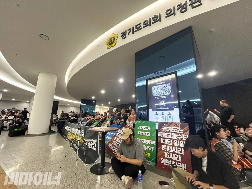 경기도 의회라고 적힌 현판 밑에 경기장차연 활동가들이 모여있다. 사진 이재민