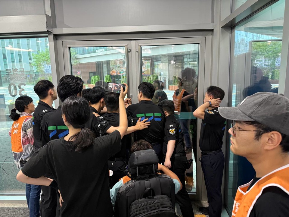 청원경찰이 경기장차연 활동가들의 출입구 이동을 막아서고 있다. 사진 경기장차연