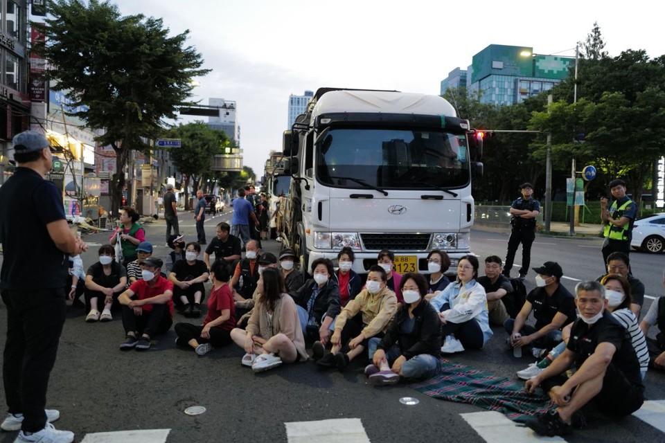 트럭 앞을 가로막고 연좌농성 중인 노점상. 사진 최인기