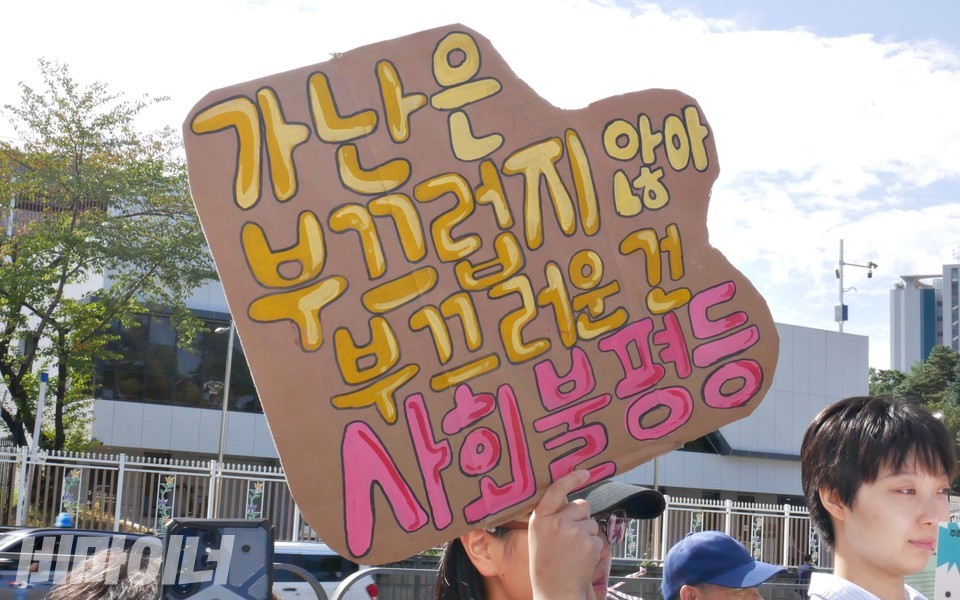 피켓에 “가난은 부끄럽지 않아, 부끄러운 건 사회불평등”이라 적혀 있다. 사진 하민지