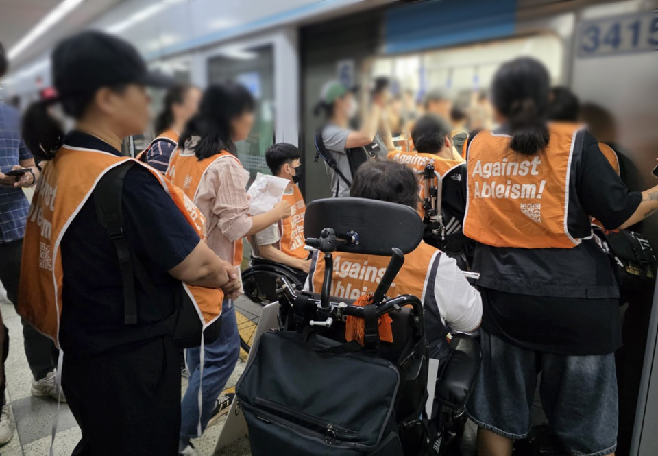 형숙의 전동휠체어 오른쪽 뒤로 주황색 우산이 꽂혀 있다. 사진 탁영희