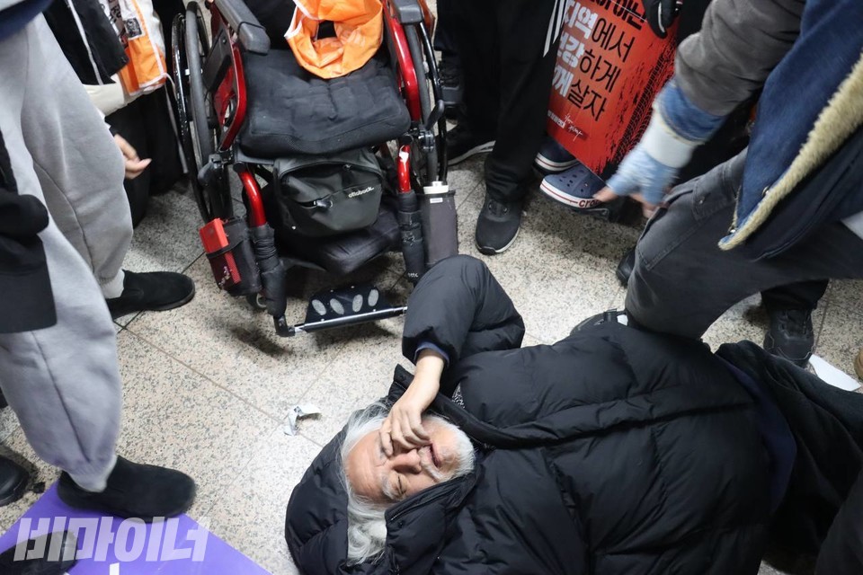 한 쪽 손잡이가 기울어진 수동휠체어와 휠체어에서 떨어진 박경석 전국장애인차별철폐연대 상임공동대표. 사진 이재민