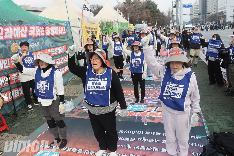 오체투지 참여자들이 손을 높게 들며 구호를 외치고 있다. 사진 김소영