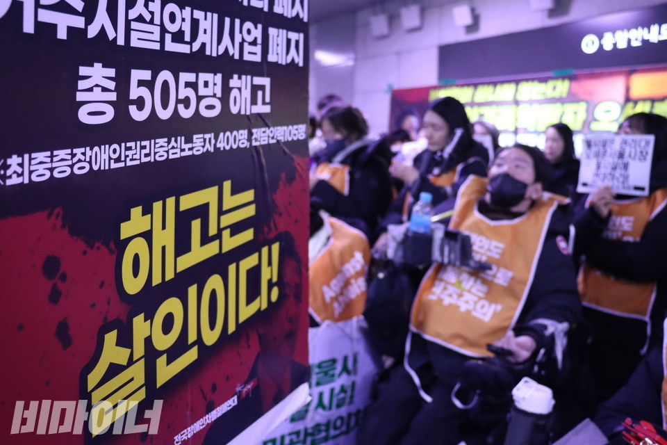    “해고는 살인이다!”라고 적힌 피켓과 결의대회에 참석한 장애인들의 모습이 함께 보인다. 사진 비마이너
