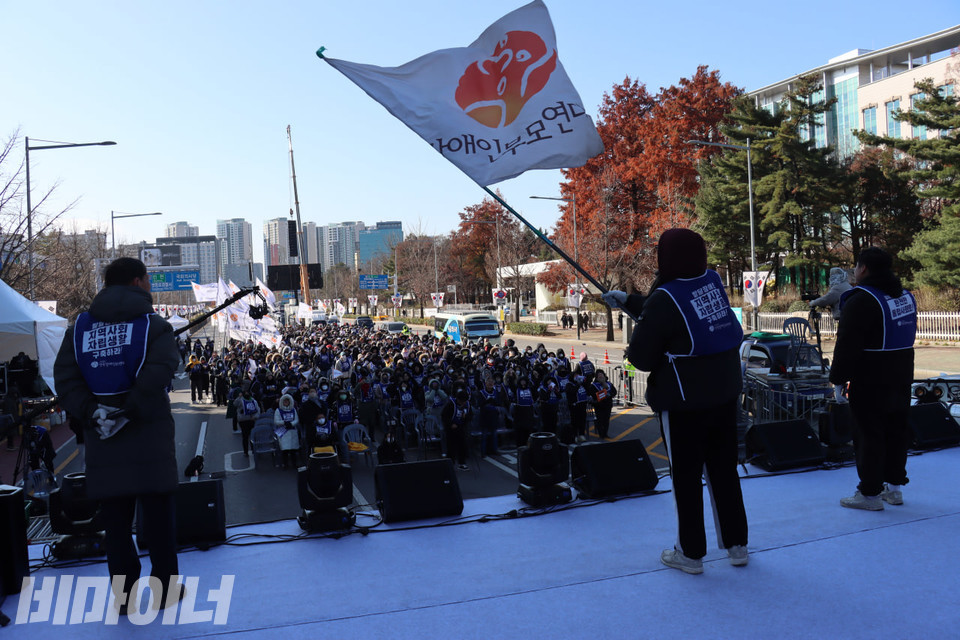 한 활동가가 무대 위에서 부모연대 깃발을 휘날리고 있다. 사진 김소영