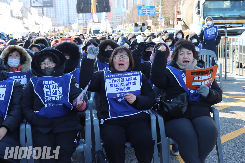 장애부모들이 주먹 쥔 손을 높이 들며 구호를 외치고 있다. 사진 김소영