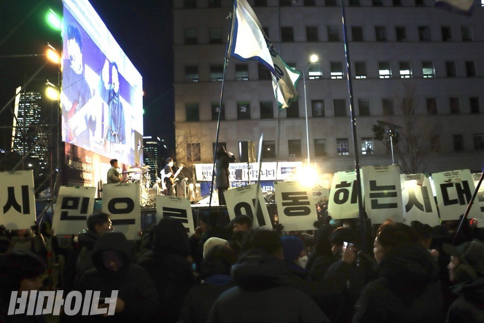 국회의사당 앞, 전장연 활동가들이 시민대행진 무대 앞에서 '장애인도 시민으로 이동하는 시대로'가 한 글자씩 적힌 피켓을 들고 있다. 사진 이재민