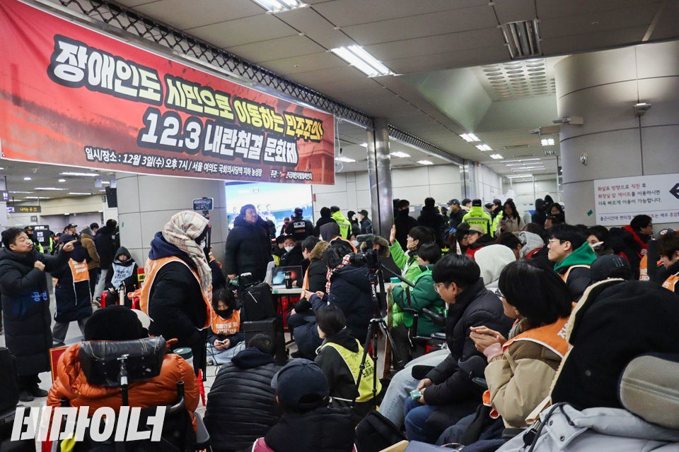 3일 오후 7시, 전국장애인차별철폐연대 회원들과 연대 시민들이 국회의사당역 대합실에서 열린 내란척결 문화제에 참여하고 있다. 사진 이재민