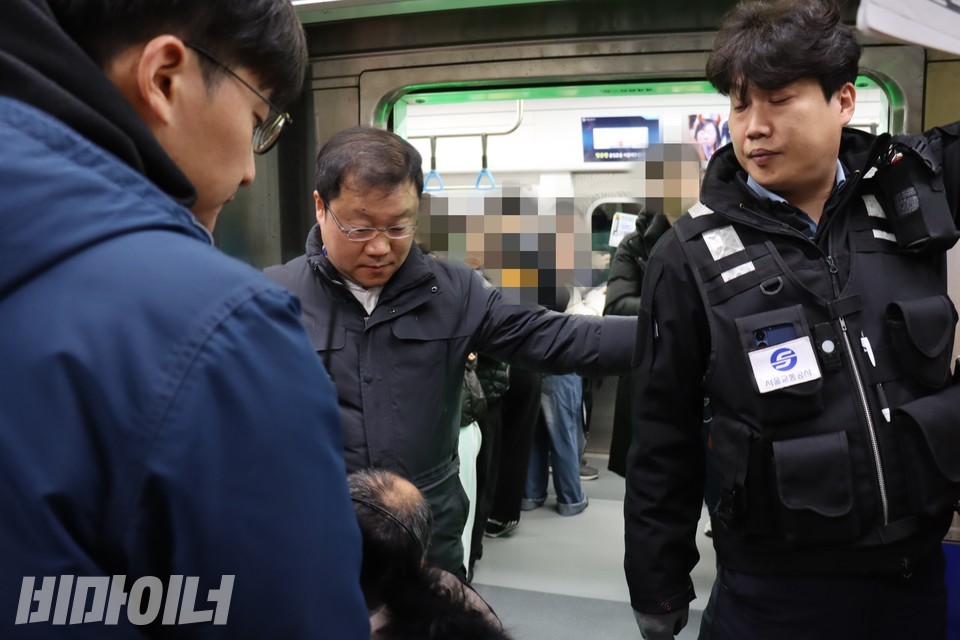 열차 안에 휠체어 탑승 공간이 충분함에도 자리가 없다며 휠체어 이용자의 다음 열차 탑승을 안내하고 있는 서울교통공사 보안관. 활동가들이 지하철을 타게 해달라고 이야기하고 있다. 사진 이재민.