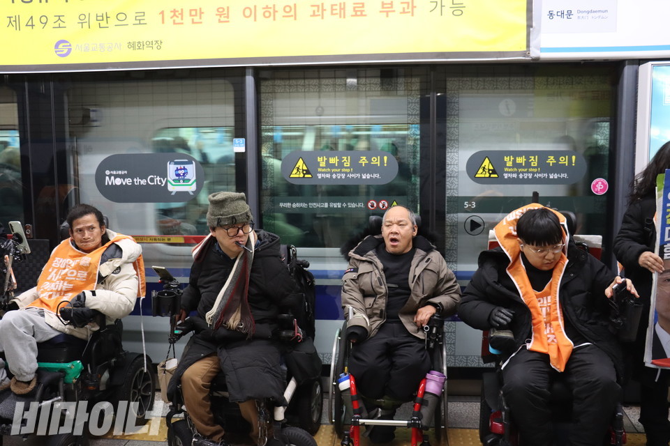 혜화역에 지하철이 무정차하자 장애인 활동가들이 스크린도어를 등지고 선전전을 이어가고 있다. 사진 이재민