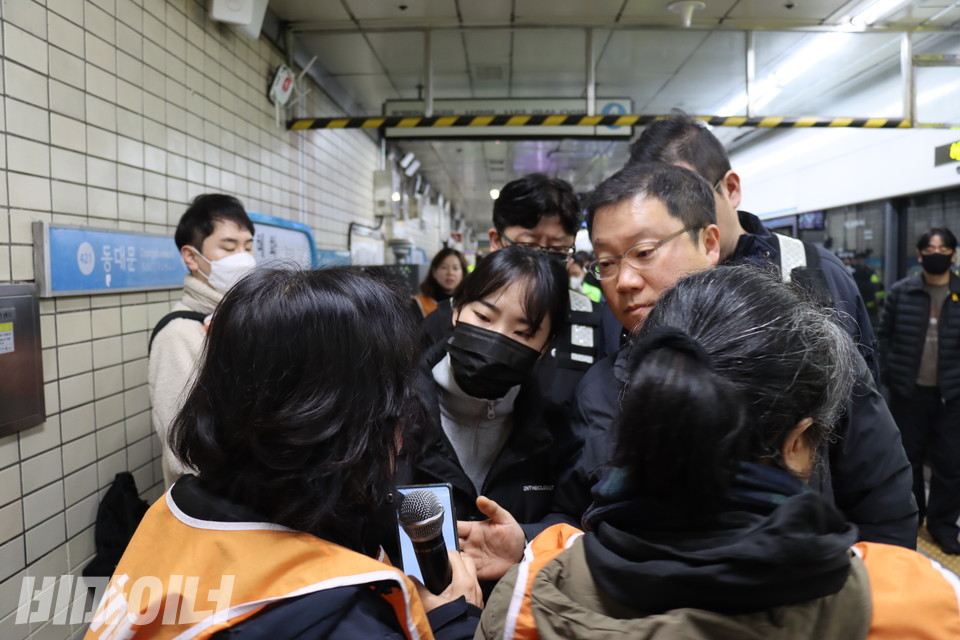 역사에서 약식 집회를 하고 있는 전장연 활동가들의 마이크를 뺏으려고 하는 서울교통공사 본사 직원과 보안관들. 사진 이재민