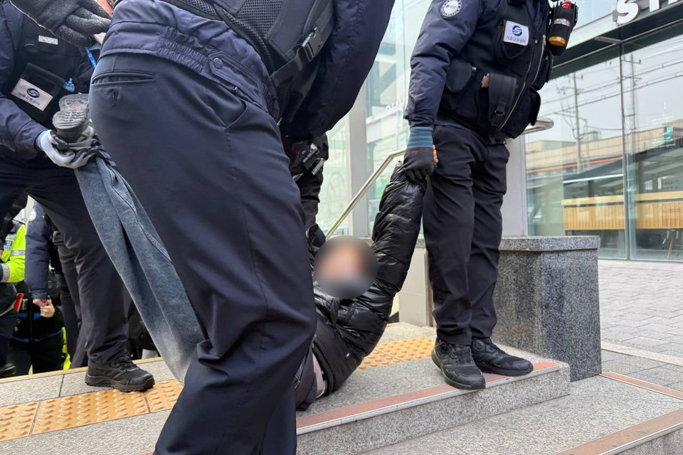 서울교통공사 보안관들이 전장연 활동가의 팔과 다리를 들고 지하철 밖으로 강제로 끌고 가고 있다. 사진 전장연