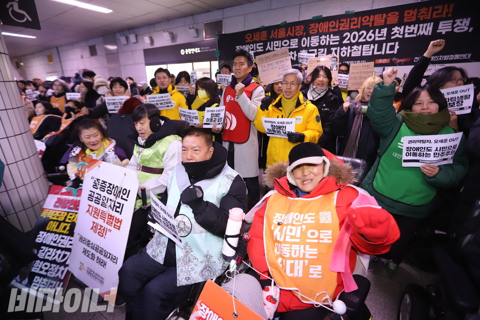 2일 오전 8시 시청역에서 진행된 ‘68차 출근길 지하철 탑니다’ 현장. 참여자들이 손을 높이 들며 구호를 외치고 있다. 사진 김소영