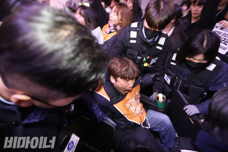 공사 보안관들이 휠체어 이용 장애인의 휠체어를 강제로 끌어내고 있다. 사진 김소영