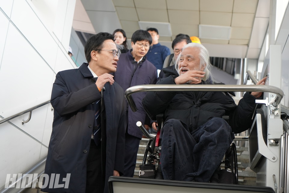 휠체어 리프트에 탑승한 박경석 전국장애인차별철폐연대 상임공동대표. 박주민 더불어민주당 의원과 이야기를 나누고 있다. 사진 이재민