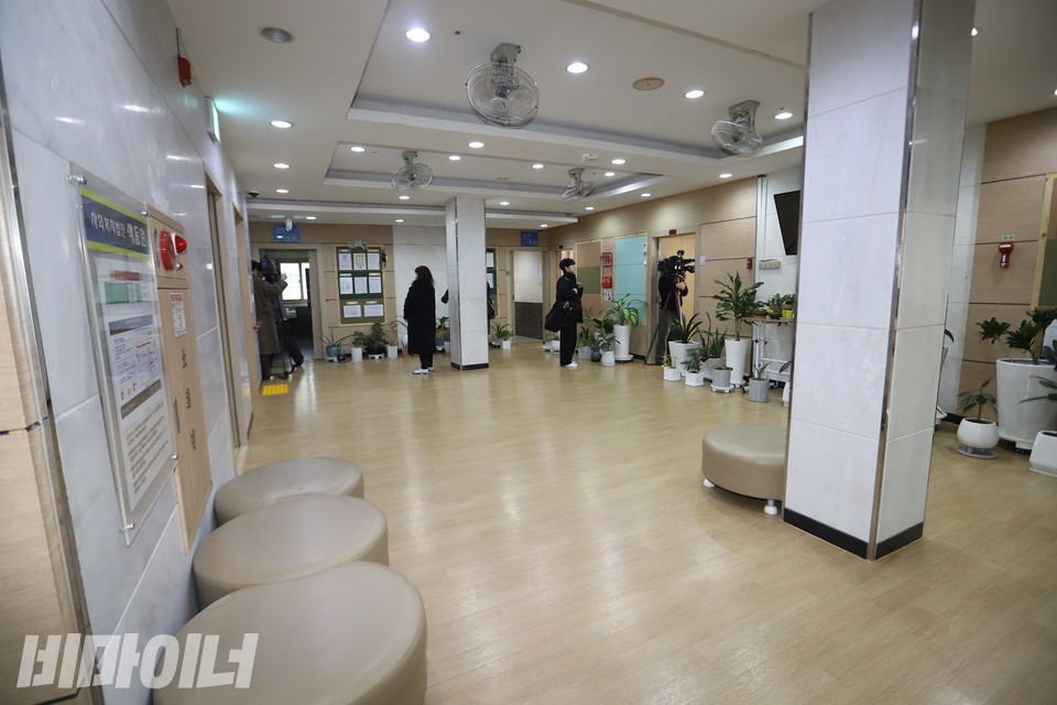 거실처럼 보이는 중앙 통로의 모습. 의자들이 바닥에 놓여 있고, 벽을 따라 화분들이 있다. 사진 김소영