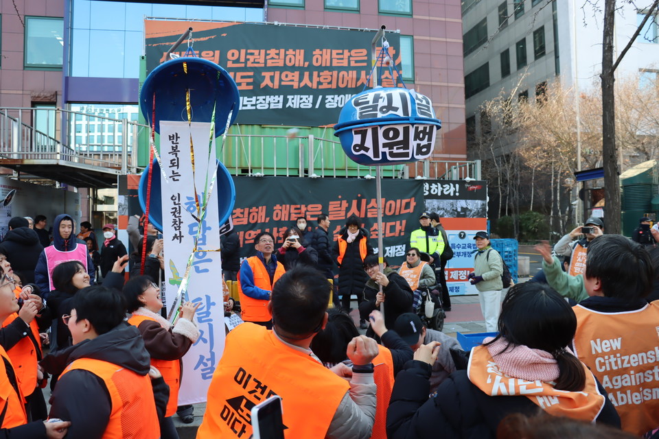 결의대회 참가자들이「탈시설지원법」, 「시설폐쇄법」이 적힌 박을 터트리기 위해 콩주머니를 던지고 있다. 사진 이재민