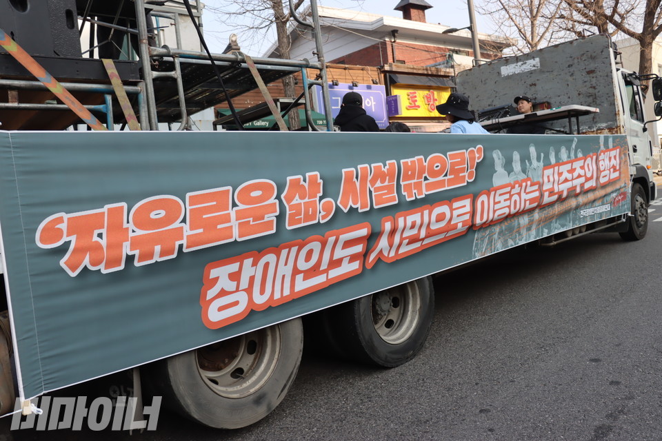 행진 차량. “‘자유로운 삶, 시설 밖으로!’ 장애인도 시민으로 이동하는 민주주의 행진”이라고 적힌 현수막이 걸려있다. 사진 김소영