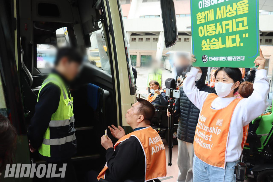 권달주 전국장애인이동권연대 대표가 운수회사 직원에게 휠체어 이용자의 버스 탑승을 요구하고 있다. 사진 이재민