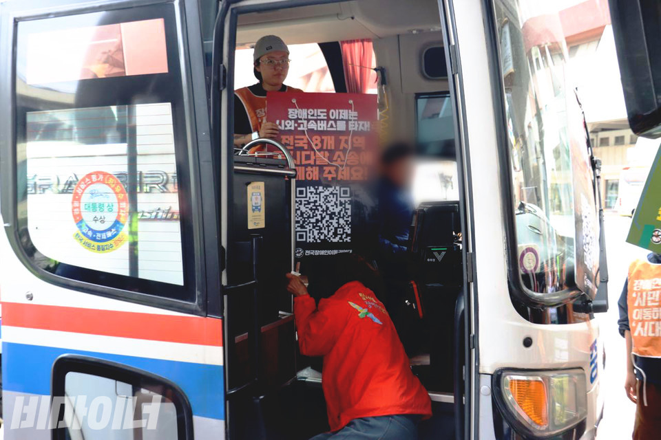 휠체어를 이용하는 장애인 활동가가 고속버스 입구의 계단을 기어 오르고 있다. 사진 이재민