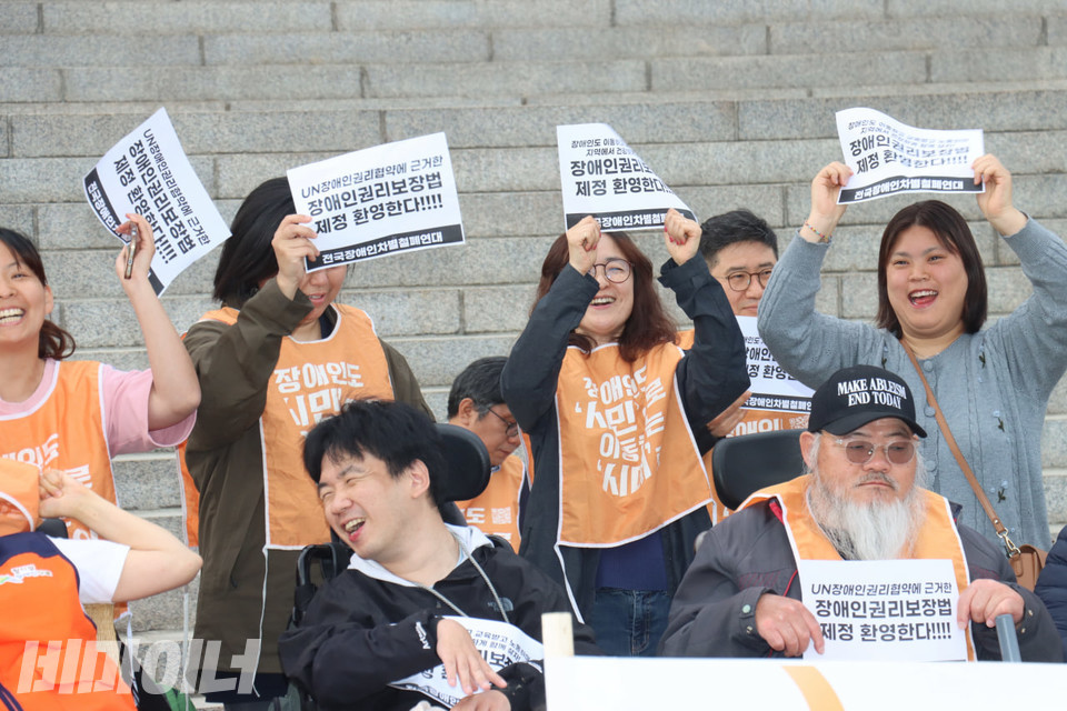 기자회견 참가자들이 “장애인권리보장법 제정 환영한다!”라고 적힌 손피켓을 들고 환히 웃고 있다. 사진 김소영