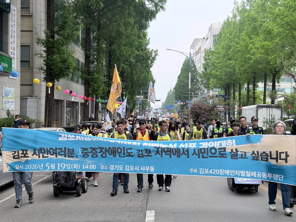 김포420공투단 활동가들이 천막농성 선포 결의대회를 마치고 김포시청 일대를 행진하고 있다. 현수막에는 “김포 시민 여러분, 중증장애인도 김포 지역에서 시민으로 살고 싶습니다”라고 쓰여있다. 사진 김포420공투단