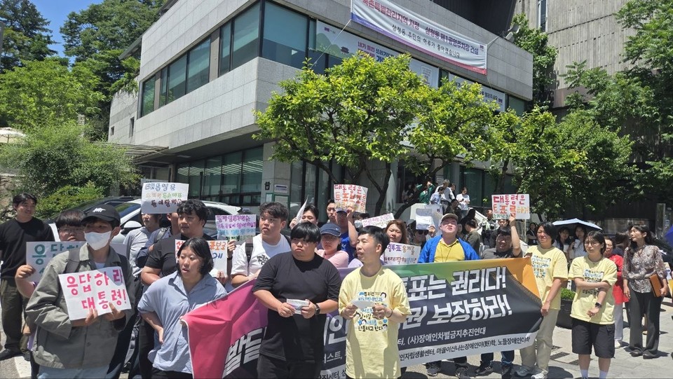 삼청동 주민센터 앞에서 피플퍼스트 활동가들이 현수막을 들고 이 대통령을 기다리고 있다. 사진 한국피플퍼스트
