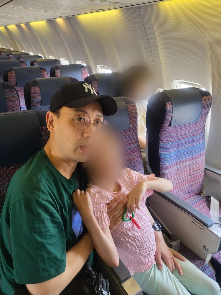 보호자가 장애아동을 비스듬히 안고 비행기 좌석에 앉아 있다. 진정인 측은 비행 내내 이 자세로 아이를 안고 있었다고 밝혔다. 사진제공 법무법인 디엘지