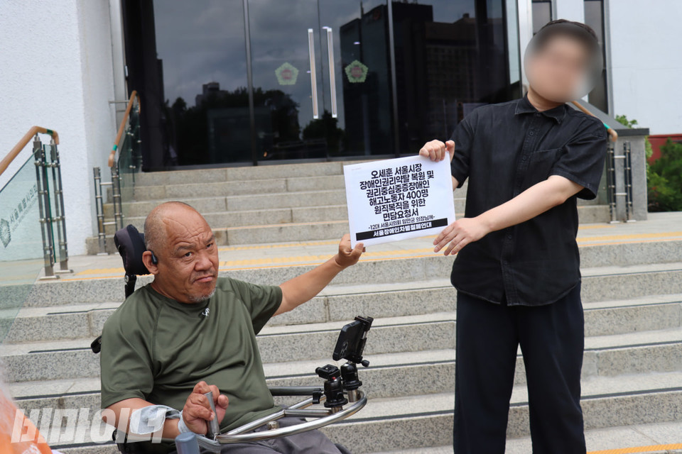 이규식 서울장차연 대표가 서울시의회 비서실 관계자에게 면담요청서를 전달하고 있다. 사진 김소영