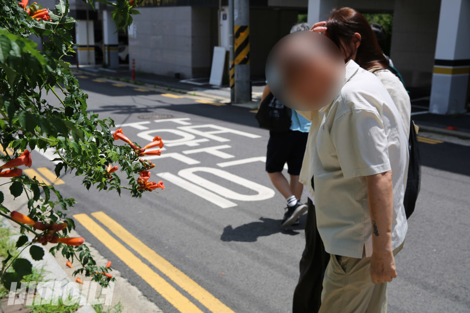 진만 씨의 집에 가는 길, 거리에 핀 능소화를 바라보고 있는 용현 씨. 사진 김소영