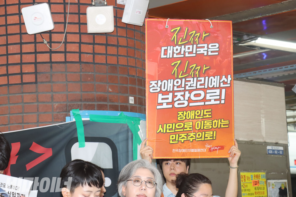 한 참가자가 “진짜 대한민국은 진짜 장애인권리예산 보장으로!”라고 적힌 피켓을 들고 있다. 사진 김소영