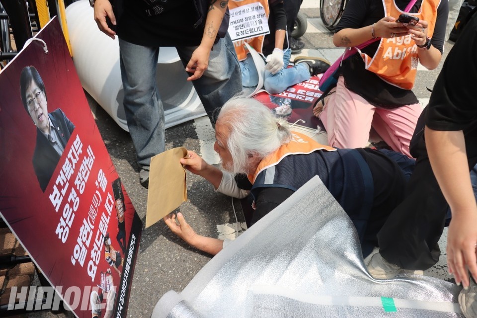 박경석 전국장애인차별철폐연대 상임공동대표가 정은경 보건복지부 장관에게 면담 요청서를 전달하기 위해 포체투지를 진행하고 있다. 사진 이재민