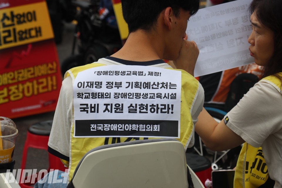 한 야학 학생이 조끼 등 쪽에 붙인 스티커. “이재명 정부 기획예산처는 학교 형태의 장애인평생교육시설 국비 지원 실현하라!”. 사진 이재민