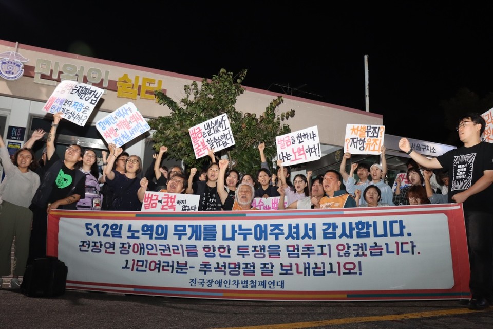 서울구치소 앞에서 전국장애인차별철폐연대 권달주∙박경석 상임공동대표를 환영하는 활동가들. 현수막에는 "512일 노역의 무게를 나누어주셔서 감사합니다. 전장연 장애인권리를 향한 투쟁을 멈추지 않겠습니다. 시민 여러분, 추석명절 잘 보내십시오!"라고 적혀 있다. 사진 이재민