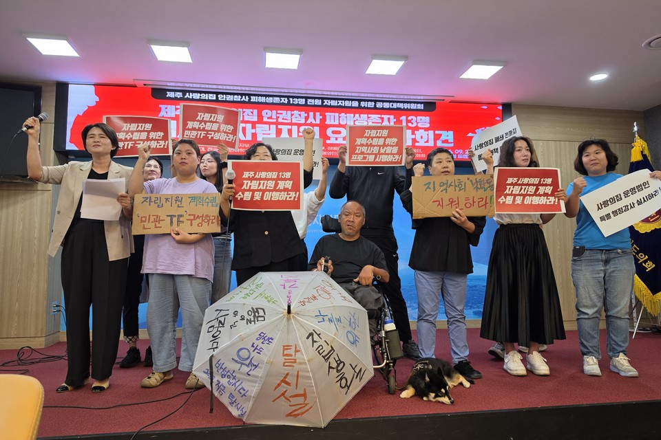 지난 28일 오전 10시 30분, 제주도의회 도민의방에서 열린 ‘제주 사랑의집 13명 자립지원 촉구 기자회견’ 현장. 참가자들이 주먹 쥔 손을 높이 들고 있다. 사진 